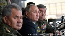13.09.2018, Russland, Telemba: Der russische Präsident Wladimir Putin (M), der russische Verteidigungsminister Sergej Schoigu (l), links, und Russlands Generalstabschef und Erster Stellvertretender Verteidigungsminister Waleri Gerassimow beobachten eine militärische Übung auf dem Übungsgelände Telemba, etwa 80 Kilometer nördlich der Stadt Tschita in Ostsibirien, beobachtet. Das einwöchige Manöver Wostok (Osten) 2018 erstreckt sich über weite Teile Sibiriens und des Fernen Ostens, der Arktis und des Pazifischen Ozeans. Es umfasst fast 300.000 russische Soldaten, 1.000 russische Flugzeuge und 36.000 Panzer und andere Kampffahrzeuge. Foto: Alexei Nikolsky/Pool Sputnik Kreml/Pool/dpa +++ dpa-Bildfunk +++