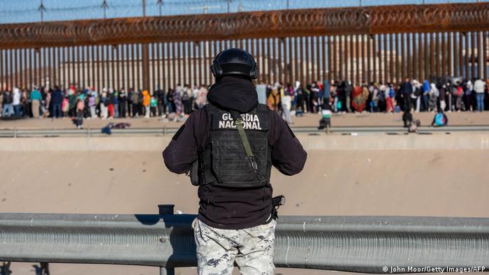 Un guardia nacional mexicano observa desde Ciudad Juárez a los migrantes que hacen fila a lo largo de la valla fronteriza entre Estados Unidos y México, para solicitar asilo en el vecino país del norte. (Archivo: 21.12.2022).