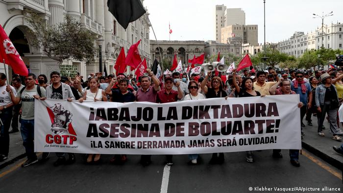 Demonstranten in Lima tragen ein Spruchband, auf dem sie Übergangspräsidentin Boluarte für die tödliche Gewalt anprangern