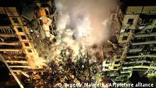 Emergency workers clear the rubble after a Russian rocket hit a multistory building leaving many people under debris in the southeastern city of Dnipro, Ukraine, Saturday, Jan. 14, 2023. (AP Photo/Evgeniy Maloletka)