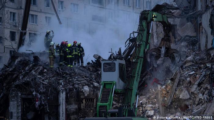 Helfer und Feuerwehrleute suchen in den Trümmern des eingestürzten Wohnhauses nach weiteren Vermissten 