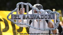 A protester holds a cut-out figure of the map of El Salvador with bars representing prison bars, during the march in San Salvador, El Salvador, Sunday, Jan. 15, 2023. Organizations that do not agree with the administration of President Nayib Bukele also marched to commemorate the 31st anniversary of the signing of the peace accords which ended the 1980-1992 civil war. (AP Photo/Salvador Melendez)