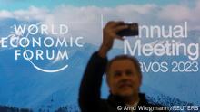 A man takes a selfie in front of the logo of the World Economic Forum (WEF) 2023 at Davos Congress Centre in the Alpine resort of Davos, Switzerland, January 15, 2023. REUTERS/Arnd Wiegmann