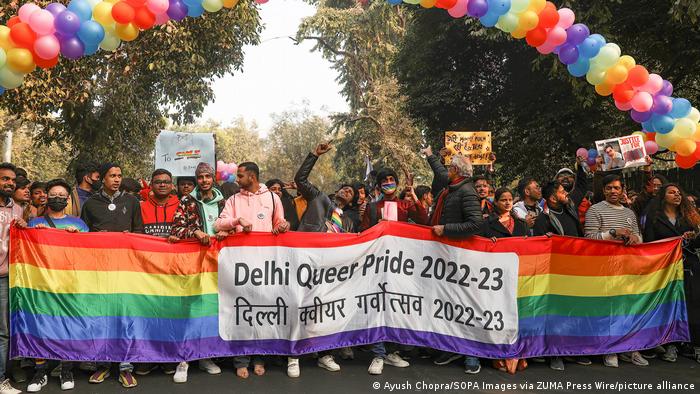 LGBTQ+-Menschen auf der Straße mit einem breiten Banner vor sich auf dem Delhi Queer Pride 2022-2023