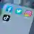 Facebook, Twitter, Instagram, TikTok icons on a phone screen