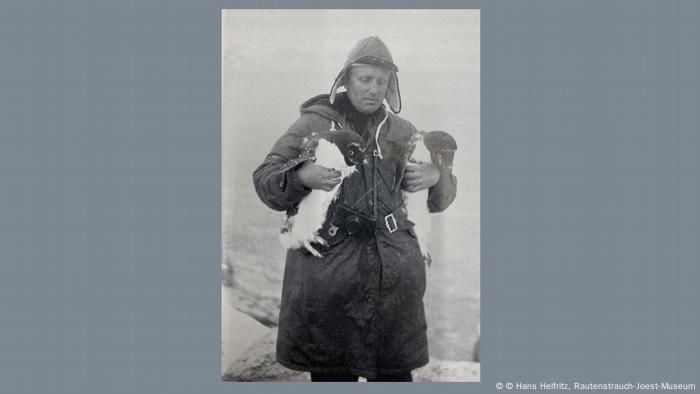 Hans Helfritz en la Antártida, sosteniendo a dos pingüinos.