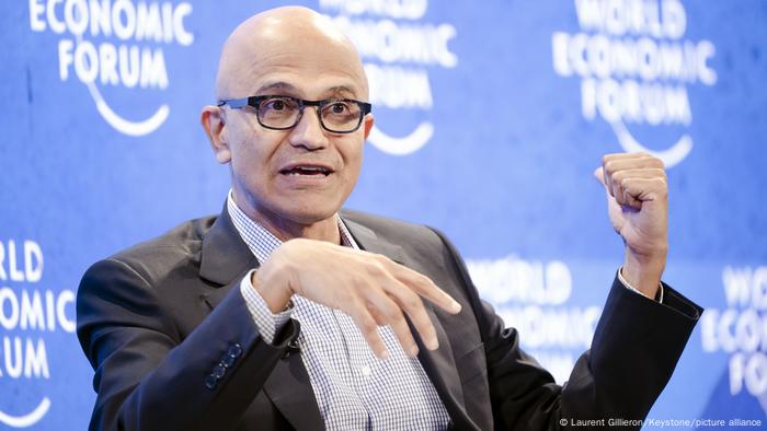 El presidente ejecutivo de Microsoft gesticula con el logo del World Economic Forum detrás.