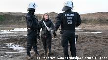 17.01.2023 *** Polizisten haben die schwedische Klimaaktivistin Greta Thunberg (M) aus einer Gruppe von Demonstranten und Aktivisten heraus und vom Rand des Braunkohlentagebaus Garzweiler II weggebracht und halten sie an den Händen fest. Aktivisten und Kohle-Gegner setzen ihre Proteste am Dienstag an mehreren Orten in Nordrhein-Westfalen fort.