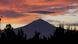 Bajo un cielo rojo de atardecer se ve la silueta negra del Popocatépetl. Bajo un cielo rojo de atardecer se ve la silueta negra del Popocatépetl.