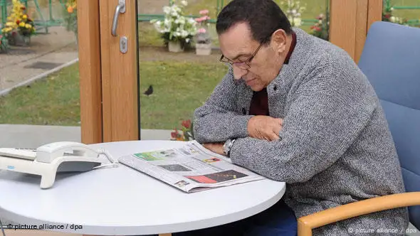 Husni Mubarak sitzt am Fenster an einem kleinen runden Tisch in der Universitätsklinik Heidelberg und liest Zeitung. (Foto: dpa)