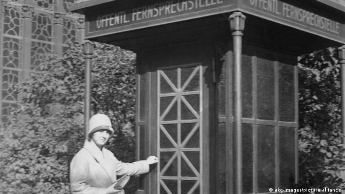 Una mujer delante de una estación telefónica en Berlin, 1927.