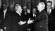 Fotografie alb-negru, document istoric din 1963: doi bărbaţi (Konrad Adenauer şi Charles de Gaulle) se îmbrăţişează. În jurul lor se află numeorşi demnitari francezi şi germani Fotografie alb-negru, document istoric din 1963: doi bărbaţi (Konrad Adenauer şi Charles de Gaulle) se îmbrăţişează. În jurul lor se află numeorşi demnitari francezi şi germani
