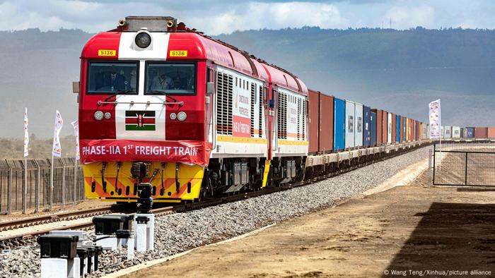 Güterzug mit Containern, vorn auf der Lok die Flagge Kenias