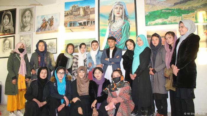 Afghanische Mädchen vor zahlreichen Bildern an der Wand 