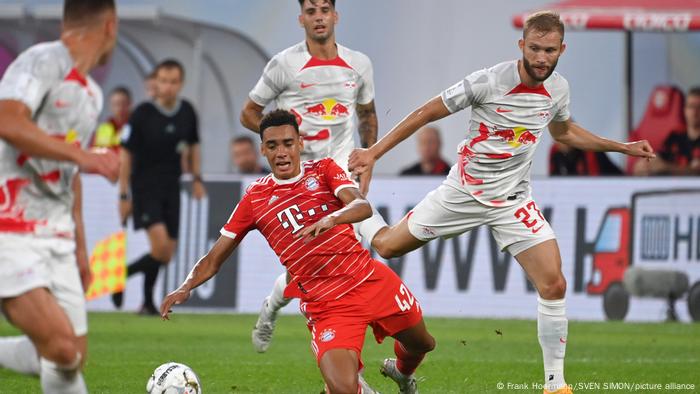 Spielszene aus DFL Supercup 2022 zwischen RB Leipzig und Bayern München, Jamal Musiala strauchelt im Zweikampf mit Konrad Laimer