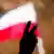 Eine Hand zeigt ein Peace-Zeichen vor einer rot-weißen Fahne