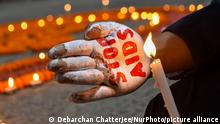 ARCHIV 01.12.2022+++ A lady is seen holding a candle with STOP AIDS message written on her palm , during a demonstration in Kolkata , India , on 1 December 2022 , to raise awareness towards prevention of AIDS on World AIDS day. (Photo by Debarchan Chatterjee/NurPhoto)
