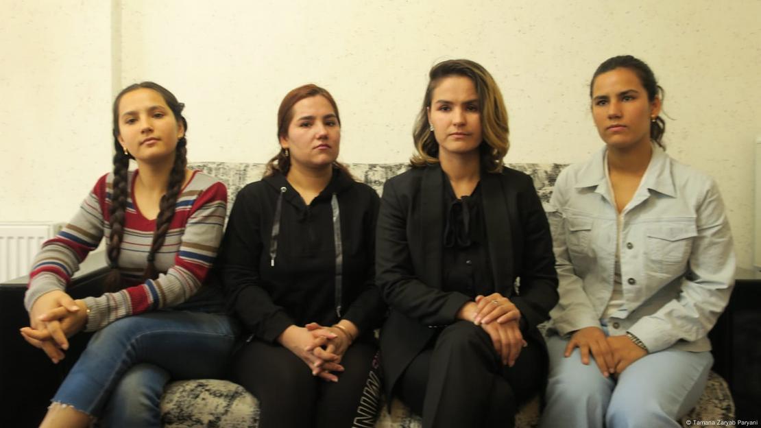 Shafiqa, Zarmina, Tamana and Kerishma Paryani sit side by side on a sofa, looking serious.