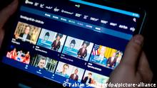 Ein Mann benutzt die ARD-Mediathek auf einem Tablet. Auf dem Bildschirm sieht man mehrere Videos der Tagesschau. (Foto: Fabian Sommer/dpa/picture-alliance)