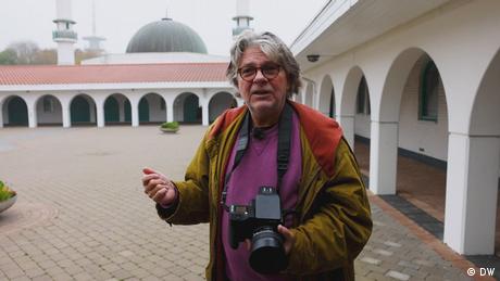 Der Fotograf Eckhard Ahmed Krausen steht im Innenhof einer Moschee. (DW)