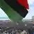 Menschenmassen in Bengasi, im Vordergrund wehr eine Fahne (Foto: AP/dapd)