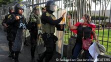 Riot police officers approach a woman during the 'Take over Lima' march against Peru's President Dina Boluarte, following the ousting and arrest of former President Pedro Castillo, in Lima, Peru January 19, 2023. REUTERS/Sebastian Castaneda
