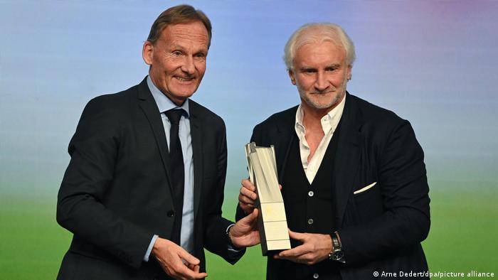 Hans-Joachim Watzke (izquierda), portavoz del Comité Ejecutivo de la DFL, entregándole un premio al exfutbolista Rudi Völler.
