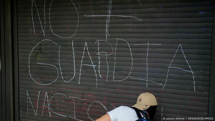 Un manifestante escribe un eslogan contra la Guardia Nacional durante una marcha pidiendo seguridad y mayor inversión en el sistema de metro de la Ciudad de México.