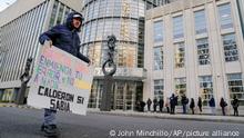 A protestor stands outside Federal court with a sign imploring contrition and cooperation upon Genaro Garcia Luna, Mexico's former top security official, in Brooklyn, Tuesday, Jan. 17, 2023, in New York. Luna goes on trial on charges of helping the Sinaloa Cartel traffic drugs and protect them from capture while he was serving as Mexico’s top security official. (AP Photo/John Minchillo)