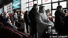 A passenger wearing personal protective equipment (PPE) queue up at Beijing West railway station ahead of the lunar new year in Beijing on January 21, 2023. (Photo by Noel CELIS / AFP)
