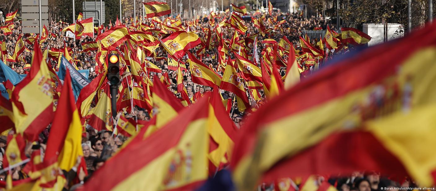 People wave Spanish flags at an anti-government protest in Madrid, Spain on January 21, 2023
