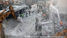 In this photo provided by Kurdish-run Hawar News Agency, civil defense workers and civilians work on the rubble of a destroyed building in the Sheikh Maksoud neighborhood in Aleppo, Syria, Sunday, Jan. 22, 2023. The building collapsed in Aleppo early Sunday, killing at least 10 people, Syrian state media reported. (Hawar News Agency via AP)