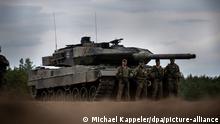 Soldaten stehen vor einem Leopard-2-Panzer der Bundeswehr, der von der NATO Enhanced Forward Presence Battle Group (eFP-Bataillon) eingesetzt wird, während des Besuchs von Bundeskanzler Scholz im Camp Adrian Rohn. Scholz hat Litauen zusätzliche militärische Unterstützung für die Verteidigung gegen einen möglichen russischen Angriff zugesagt.