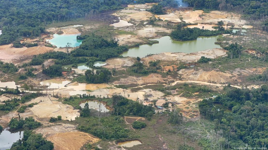 Foto aérea mostra crateras com água parada em região desmatada de floresta