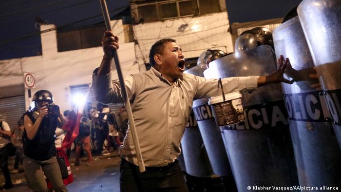 Un hombre se enfrenta a policías antidisturbios en Lima.