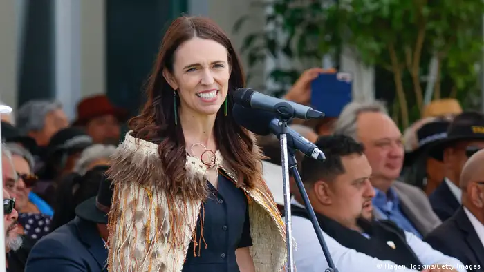 Neuseeland Premierministerin Jacinda Ardern spricht in traditionellem Maori-Federmantel auf einer Veranstaltung vor Gästen in ein Mikrofon