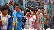 Tourists taking photos at the Berlin Wall. 