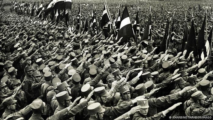 NSDAP-Aufmarsch im Jahr 1932 mit Uniformierten, die den Hitlergruß machen 