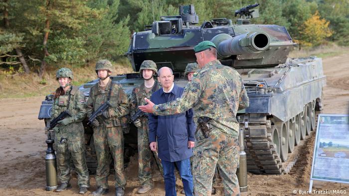El canciller alemán, Olaf Scholz, rodeado de militares, delante de uno de los carros de combate Leopard 2 A6 de la Bundeswehr.