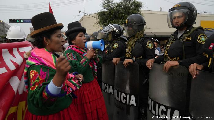 Protesta de indígenas peruanas frente a policías.