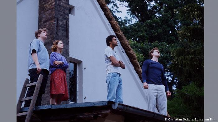In einer Szene des Films Roter Himmel stehen vier Menschen auf dem Dach eines Hauses.