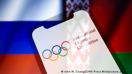 Grafik olympische Ringe und Schriftzug International OIympic Committee vor russischer und belarussischer Fahne