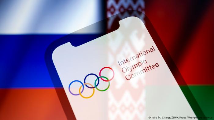 Graphic Olympic rings and lettering International Olympic Committee in front of the Russian and Belarusian flags