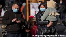 A family visit the Qianmen pedestrian shopping street, a popular tourist spot in Beijing, Tuesday, Jan. 17, 2023. China has announced its first population decline in decades as what has been the world's most populous nation ages and its birthrate plunges. (AP Photo/Andy Wong)