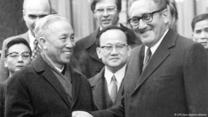 Die beiden Chefunterhändler Henry Kissinger (USA, r) und Le Duc Tho (Nordvietnam) reichen sich nach erfolgreichem Abschluss ihrer Verhandlungen vor dem Konferenzgebäude in Paris die Hände (31.12.1972)