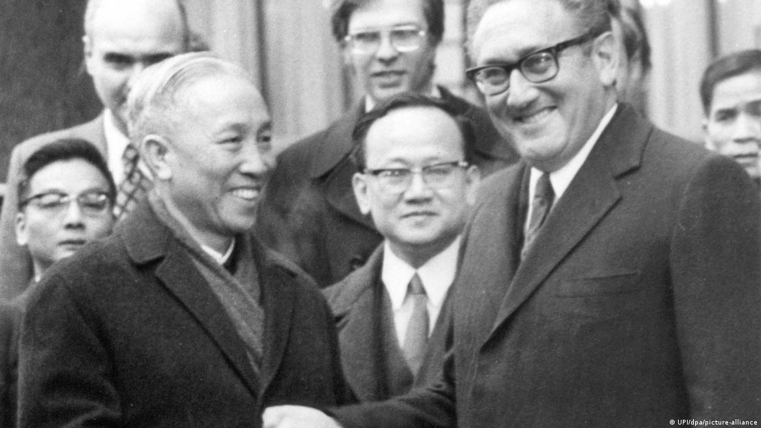 Henry Kissinger and Le Duc Tho shake hands