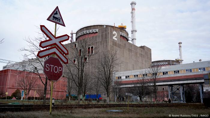 Se ve el edificio del reactor número 2 de la central nuclear con una señal de Stop en primer plano.