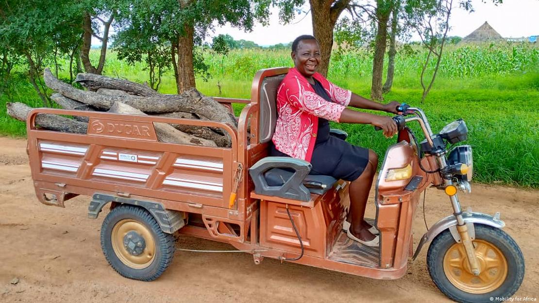 A woman transporting firewood from the fields on a tricycle