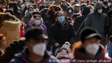Besucher mit Gesichtsmasken spazieren am ersten Tag des Mondneujahrsfestes in Peking durch die Fußgängerzone Qianmen. Am Sonntag läuteten die Menschen in ganz China das Neujahrsfest mit großen Familientreffen und Tempelbesuchen ein, nachdem die Regierung ihre strenge Null-COVID-Politik aufgehoben hatte. Dies war das größte Fest seit Beginn der Pandemie vor drei Jahren. +++ dpa-Bildfunk +++