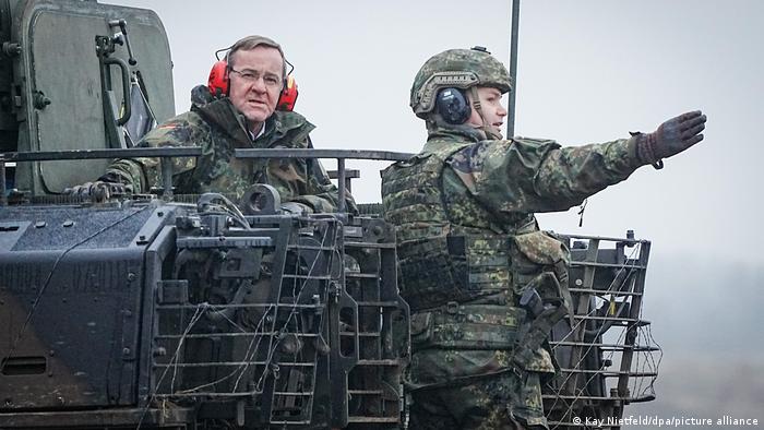 Deutschland Verteidigungsminister Pistorius steht mit rotem Ohrenschutz auf einem Panzer